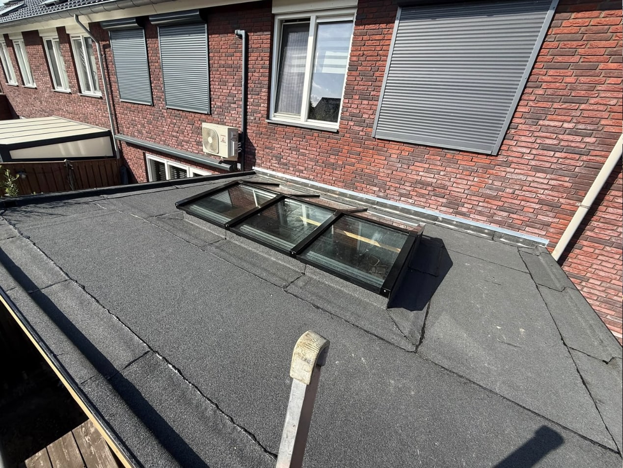De lichtstraat tegen de achtergevel, rondom ingewerkt in de dakbedekking