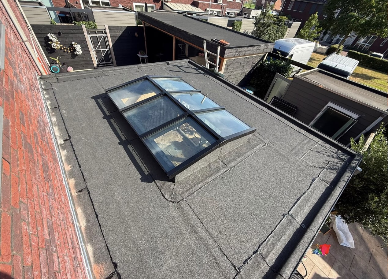 Nieuw plat dak van een aanbouw met bitumen dakbedekking en een ingewerkte lichtstraat